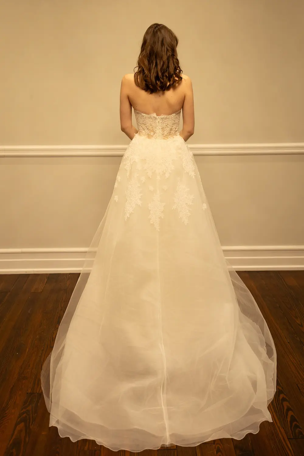 uploads-1771347460652-RH001-4 Juliet - This striking mermaid wedding gown is designed to contour and captivate. The strapless silhouette features an illusion bodice with exposed boning, offering a modern, structured look that seamlessly blends with romantic lace appliqués cascading over the bodice and down the fitted skirt.