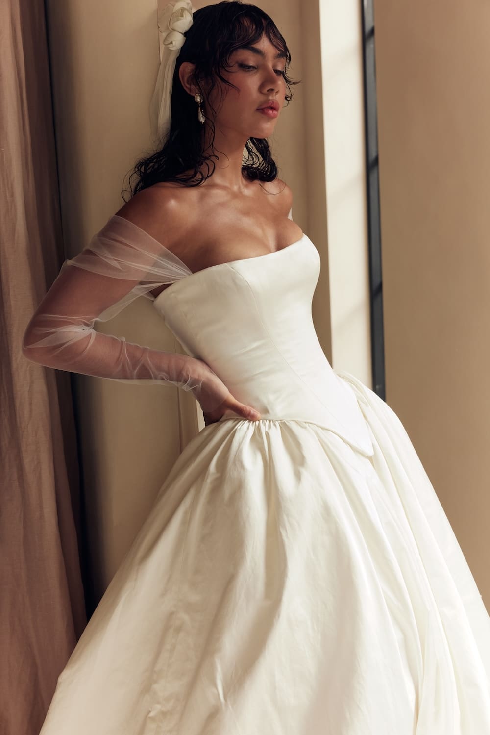 1747163533274-leah-da-gloria_03_128 Elizabeth, a natural white bridal gown by Leah Da Gloria, a strapless satin ballgown featuring a structured Basque waist, a voluminous skirt, and romantic, detachable off-the-shoulder tulle sleeves.