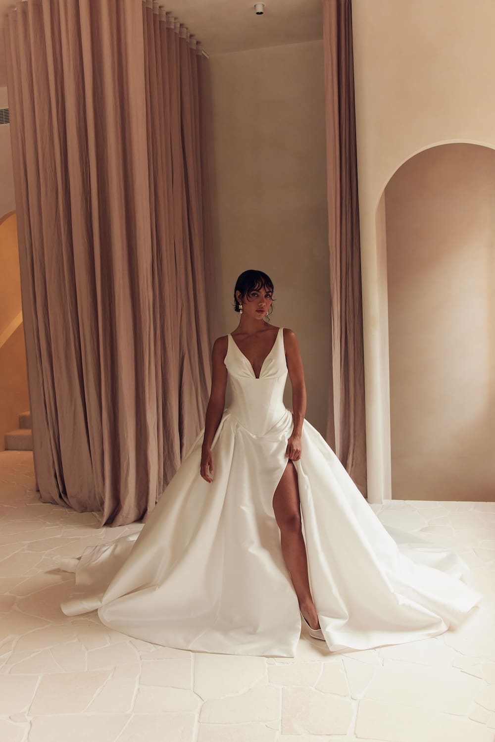 1747164154899-leah-da-gloria_14_054 Carter, a natural white modern ballgown by Leah Da Gloria, crafted from luminous mikado with a sculpted Basque waist, small plunging neckline, medium-sized straps, and a full skirt with a high slit.