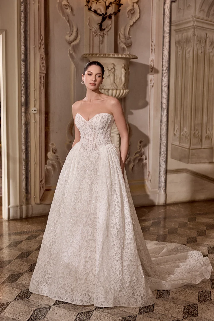 1747243543709-88485_Love_JAB_SS26_FF_Justin-Alexander_2-1 Love, a sand, ivory, and latte ballgown by Justin Alexander, features a strapless sweetheart neckline and an allover beaded and sequined lace design with crystals and pearl detailing. The demi-sheer bodice has exposed boning and a flattering Basque waist, transitioning to a voluminous skirt with side gathering and a chapel-length train.