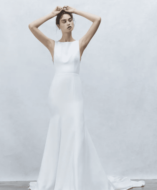 1738867446996-lena-alyne1 Luna, an ivory Alyne bridal gown, features a modest bateau neckline with tank straps, a sheath silhouette that transitions into a fit-and-flare skirt, a low back, and a cathedral train, all crafted from smooth crepe fabric.
